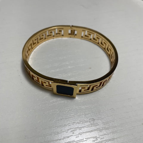 Gold bracelet with a black square clasp
