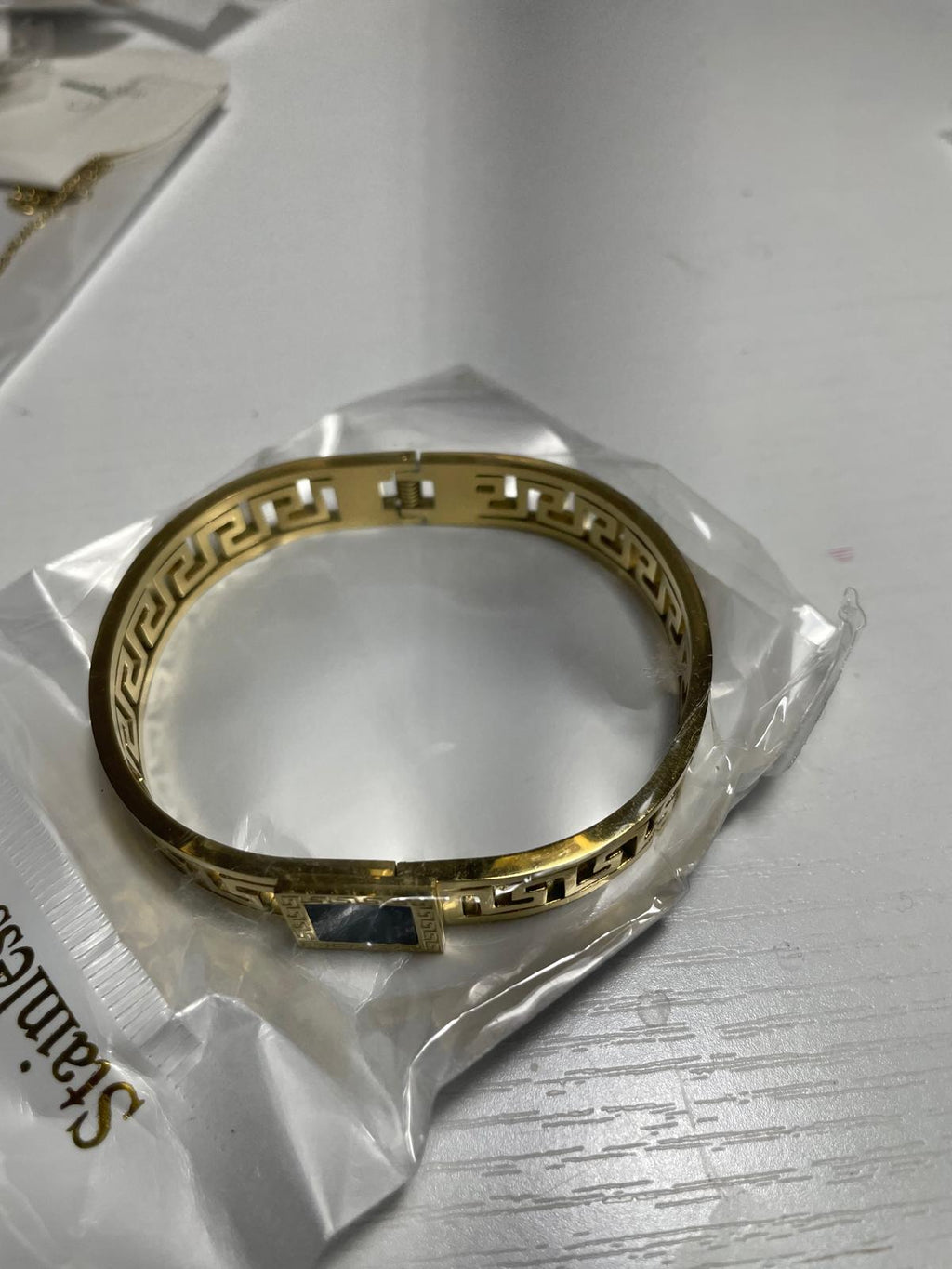 Gold bracelet with a black square clasp