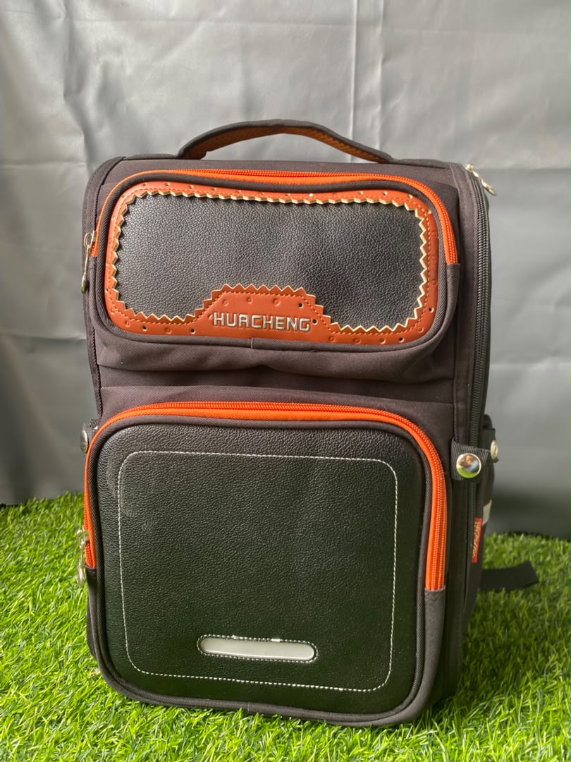 Dark brown and black Hucheng backpack with bright orange accents