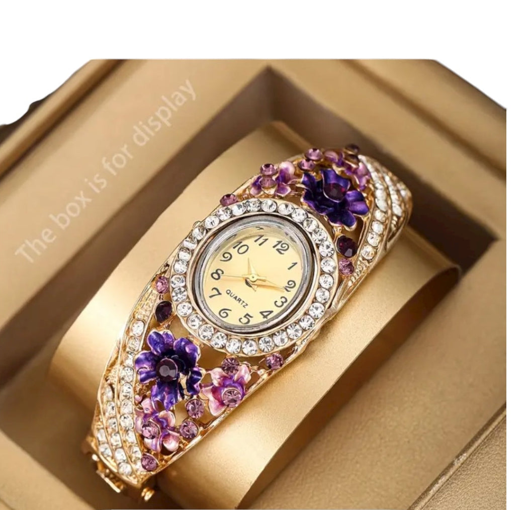 Decorative wristwatch with floral design and gemstones.
